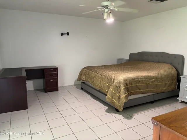 a bedroom with a bed and a lamp on the dresser