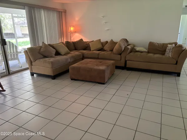 a living room with furniture and a floor to ceiling window