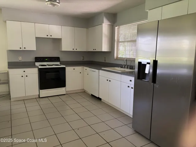 a kitchen with stainless steel appliances granite countertop a refrigerator sink and cabinets