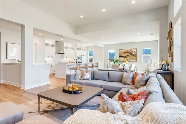 a kitchen with stainless steel appliances granite countertop a stove top oven a sink dishwasher and a dining table with wooden floor