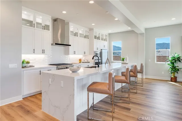 a large white kitchen with sink and wooden floor