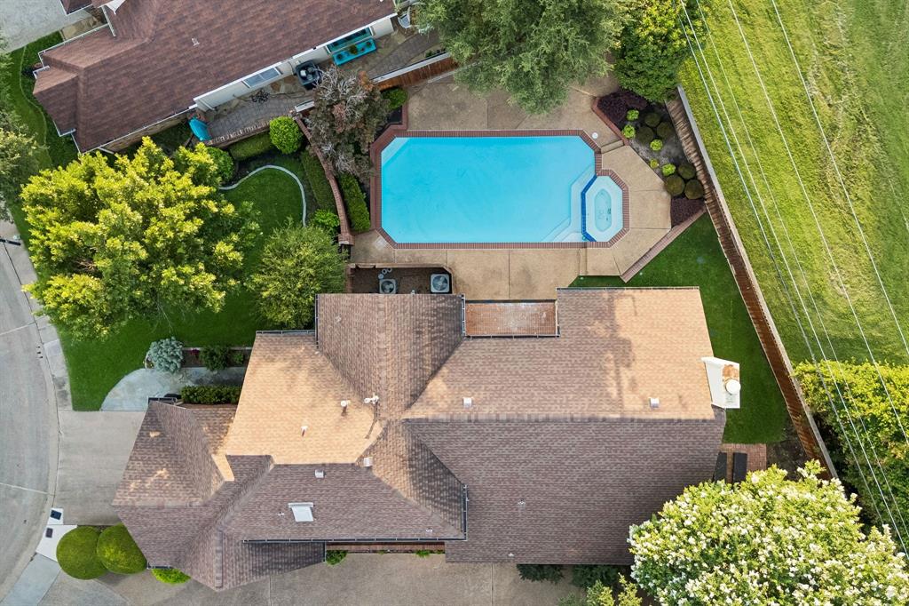 4115 Rive Lane Addison, TX 75001 - Photo 18 of 25 Backyard featuring a rectangular swimming pool with integrated spa, concrete decking, and mature landscaping