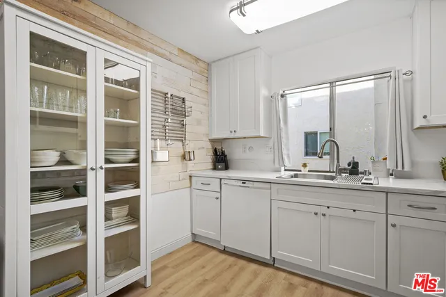 a kitchen with stainless steel appliances white cabinets and a stove a oven with wooden floor