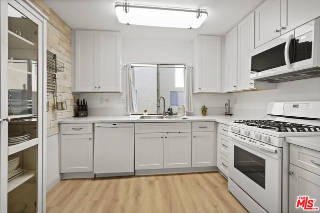 a bedroom with a bed a mirror on table and a window