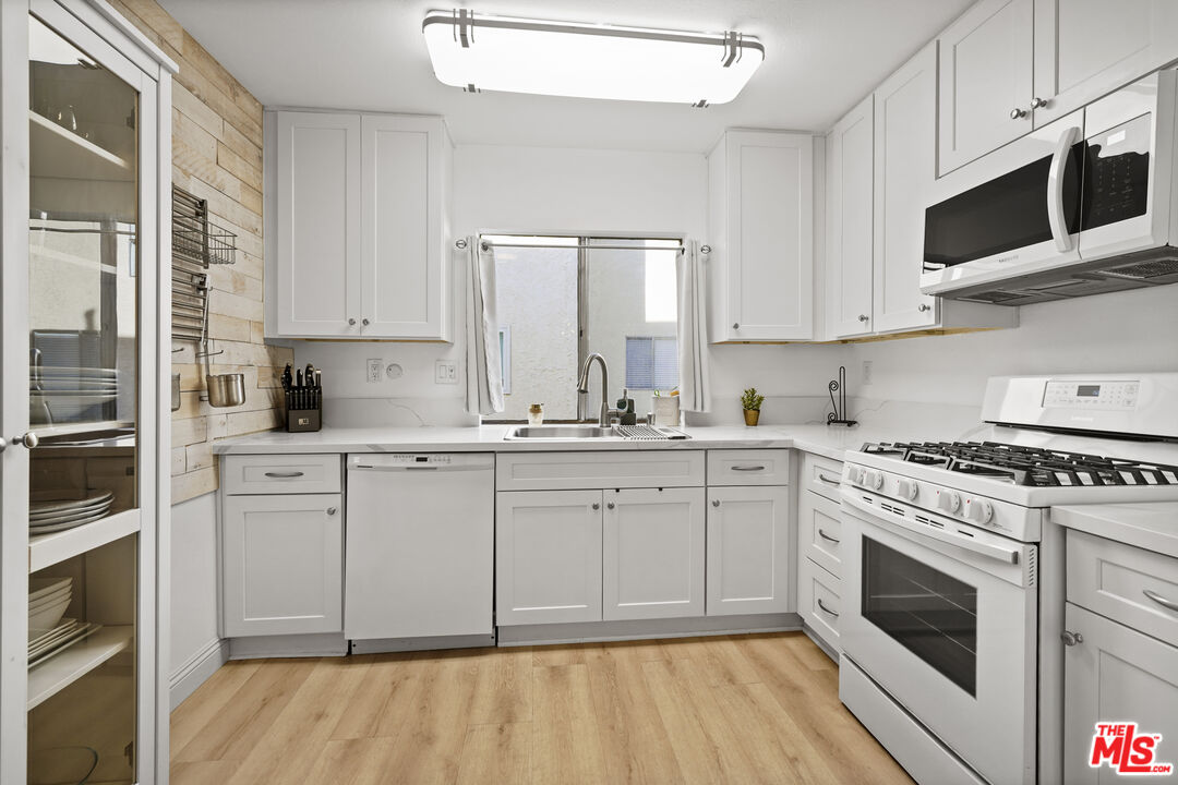 5245 Coldwater Canyon Avenue, Unit C Sherman Oaks, CA 91401 - Photo 13 of 55 a kitchen with stainless steel appliances granite countertop a stove a sink and a microwave