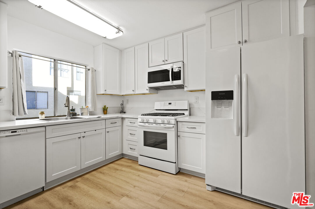 5245 Coldwater Canyon Avenue, Unit C Sherman Oaks, CA 91401 - Photo 14 of 55 a kitchen with stainless steel appliances granite countertop a stove a sink and a microwave