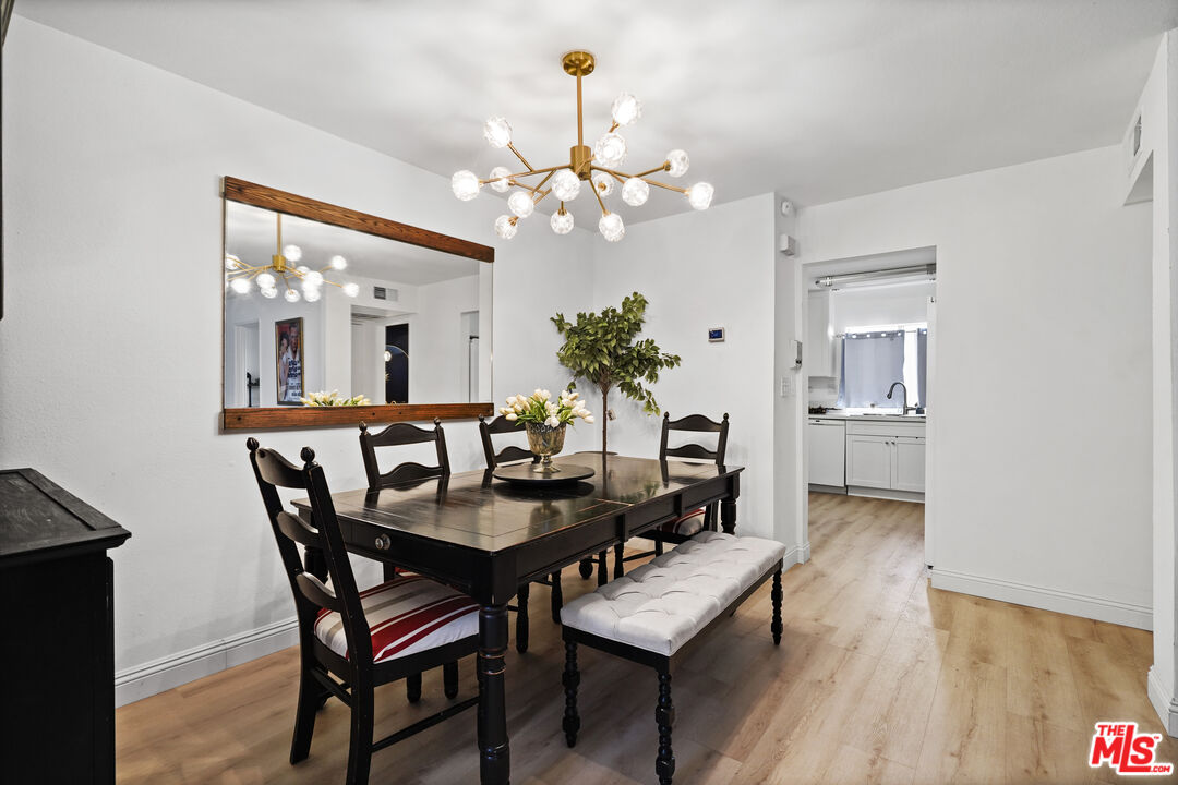 5245 Coldwater Canyon Avenue, Unit C Sherman Oaks, CA 91401 - Photo 9 of 55 a dining room with wooden floor a chandelier a wooden table and chairs