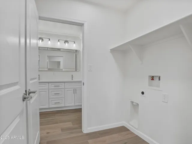 a view of an empty room with wooden floor and a ceiling fan