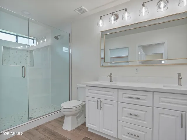 a bedroom with a bed and a lamp on dresser