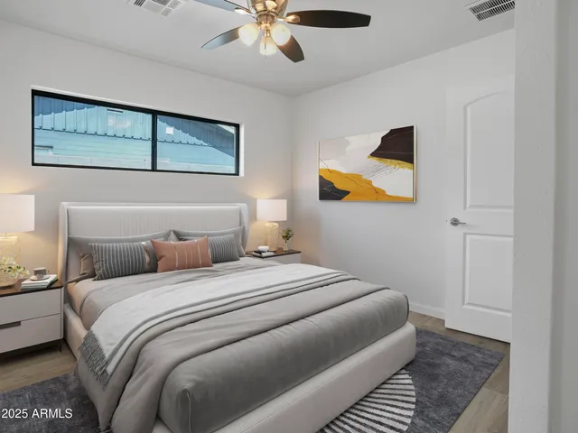 an empty room with wooden floor and ceiling fan