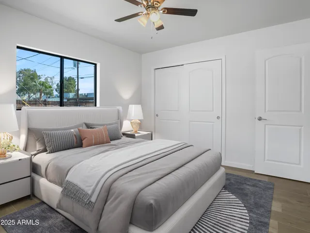 an empty room with wooden floor chandelier fan and windows