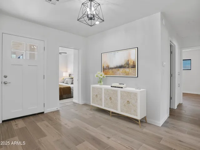 a view of a hallway with wooden floor and cabinet