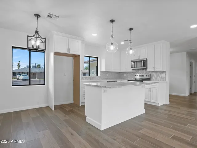 a kitchen with stainless steel appliances granite countertop a stove a sink and a refrigerator