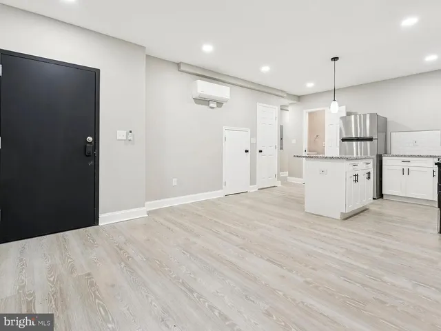 a kitchen with stainless steel appliances a refrigerator and wooden floor