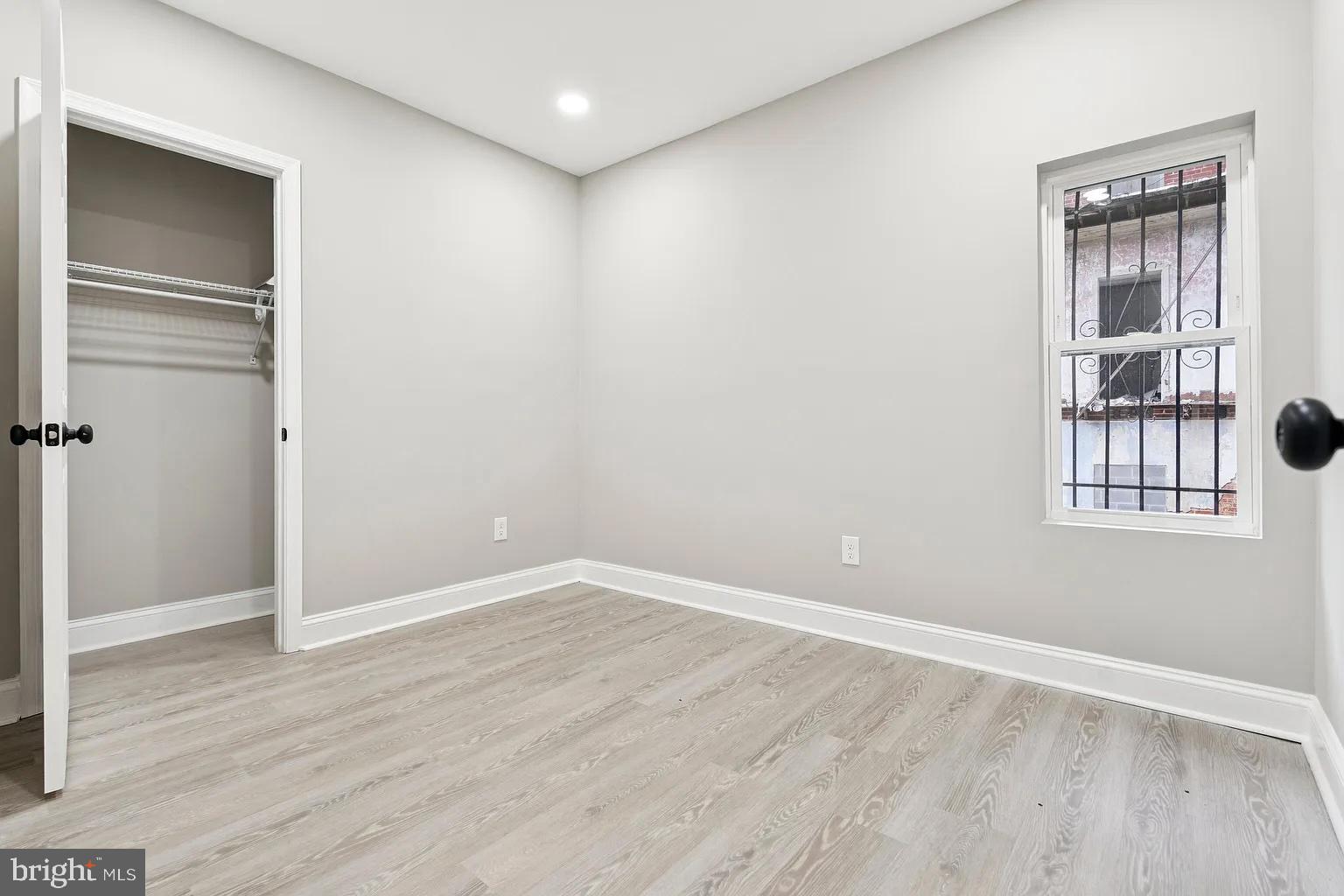 916 North Arlington Avenue, Unit 1 Baltimore, MD 21217 - Photo 12 of 14 a view of an empty room with wooden floor and windows