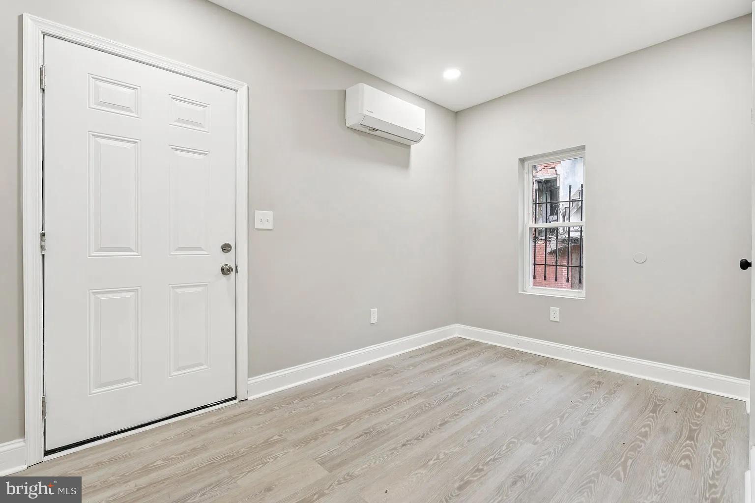 916 North Arlington Avenue, Unit 1 Baltimore, MD 21217 - Photo 14 of 14 an empty room with wooden floor and windows