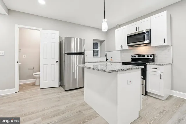 a kitchen with stainless steel appliances granite countertop a refrigerator stove microwave and sink