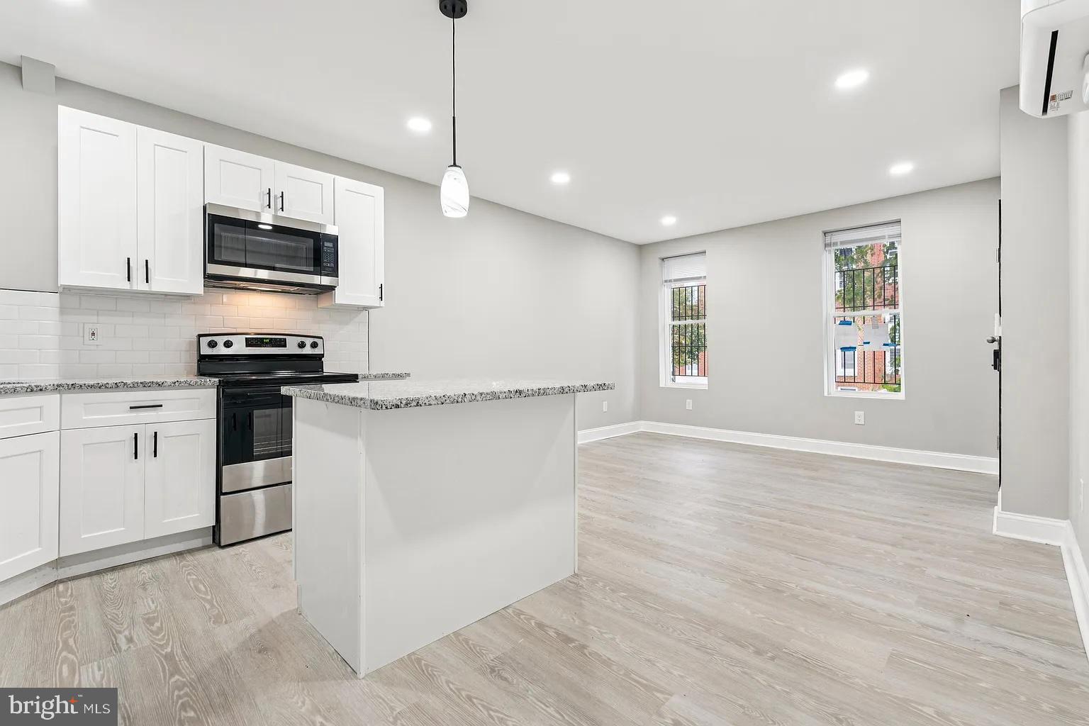 916 North Arlington Avenue, Unit 1 Baltimore, MD 21217 - Photo 3 of 14 a kitchen with stainless steel appliances granite countertop a stove and a refrigerator