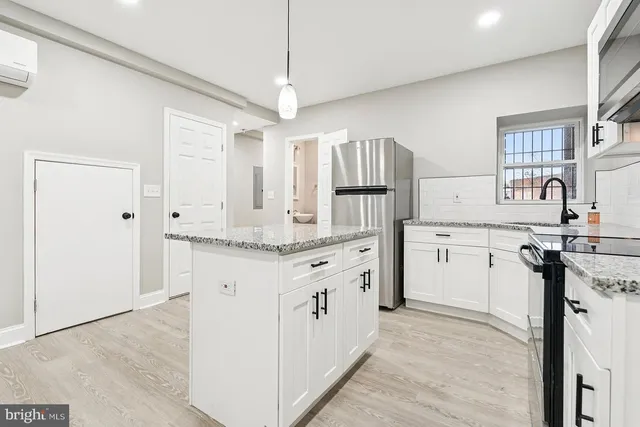 a kitchen with granite countertop a sink stove and refrigerator