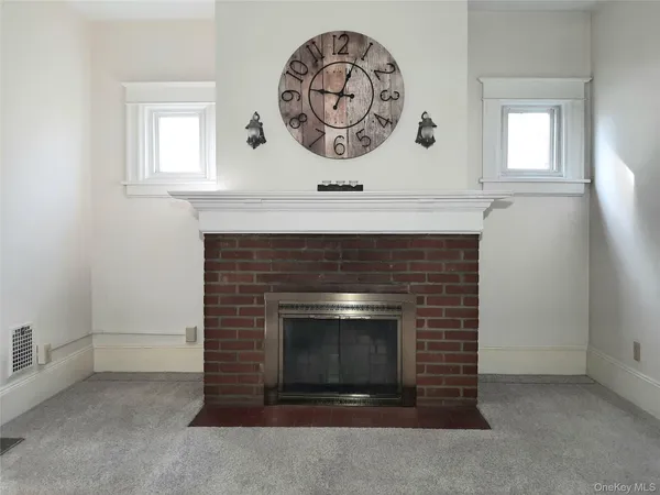 storage room with a fireplace and a window