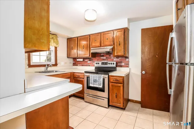 a kitchen with stainless steel appliances a stove sink and refrigerator