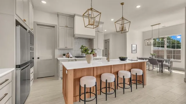 a kitchen with granite countertop a table chairs stainless steel appliances and cabinets