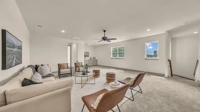 a view of a livingroom with furniture and a ceiling fan