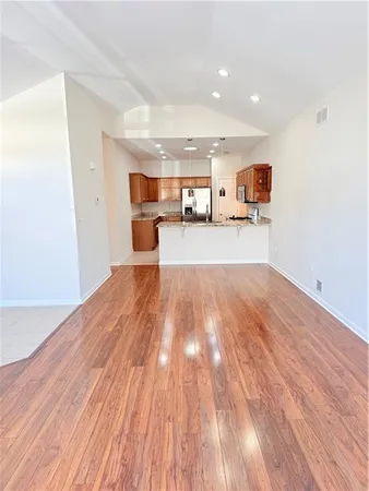 a view of a living room hardwood floor and a kitchen