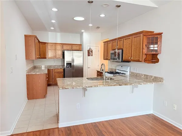 a kitchen with stainless steel appliances granite countertop a sink and a refrigerator