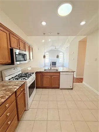 a kitchen with a sink a stove top oven a counter space and cabinets