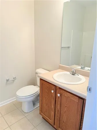 a bathroom with a granite countertop sink and a toilet
