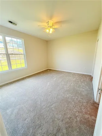 an empty room with a ceiling fan and window