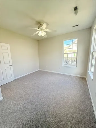 an empty room with a window and a fan