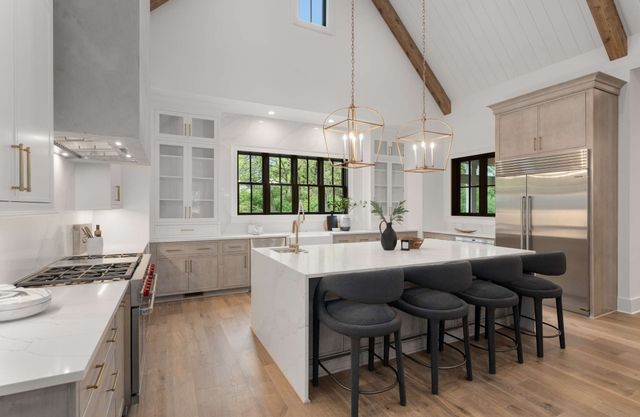 a kitchen with kitchen island granite countertop a sink and cabinets