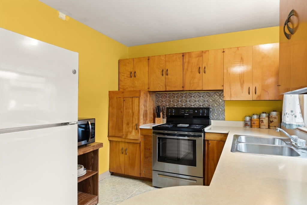 4 Vernon Street Ayer, MA 01432 - Photo 3 of 23 a kitchen with stainless steel appliances a stove a refrigerator a sink a stove with wooden cabinets
