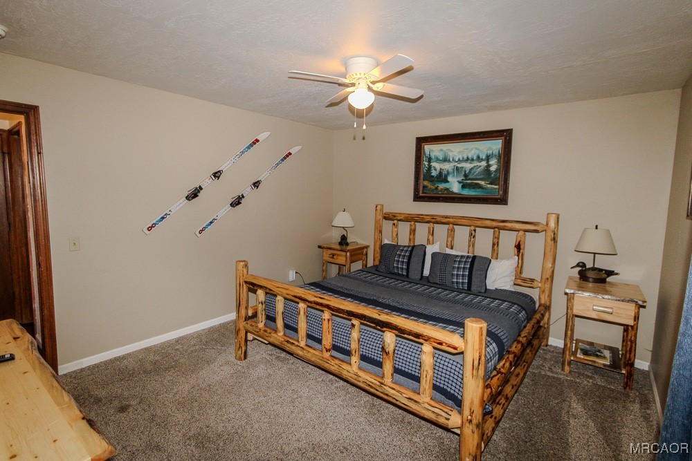 664 Knight Avenue Big Bear Lake, CA 92315 - Photo 29 of 35 a bedroom with bed and a chandelier