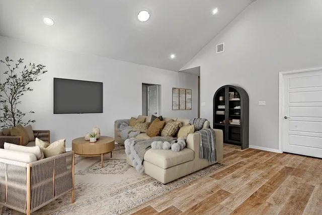 a living room with furniture a flat screen tv and a potted plant