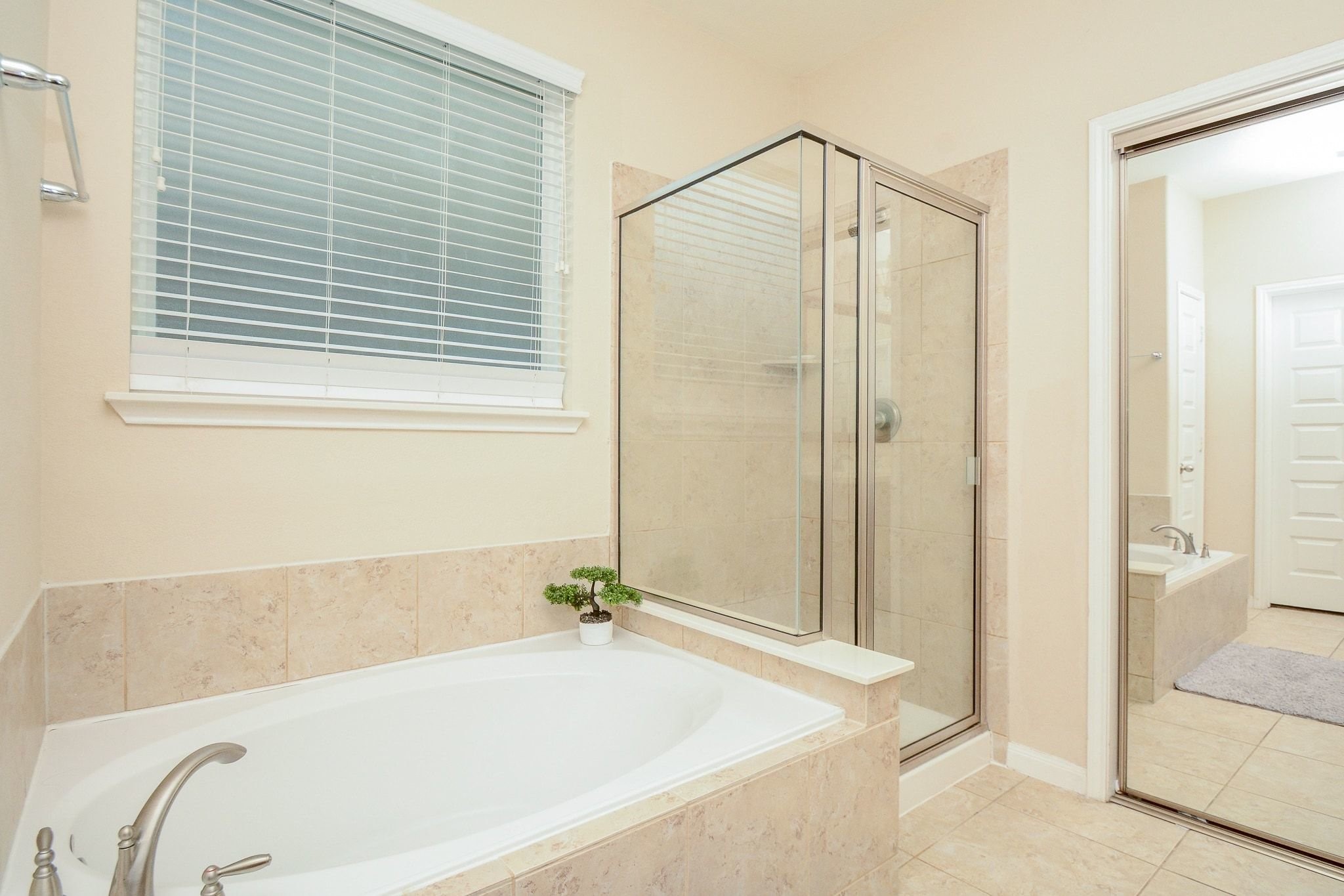 7046 Sliding Rock Circle Spring, TX 77379 - Photo 17 of 41 Indulge in luxury with a spacious soaking tub, elegant tile, and a sleek glass shower for ultimate relaxation.