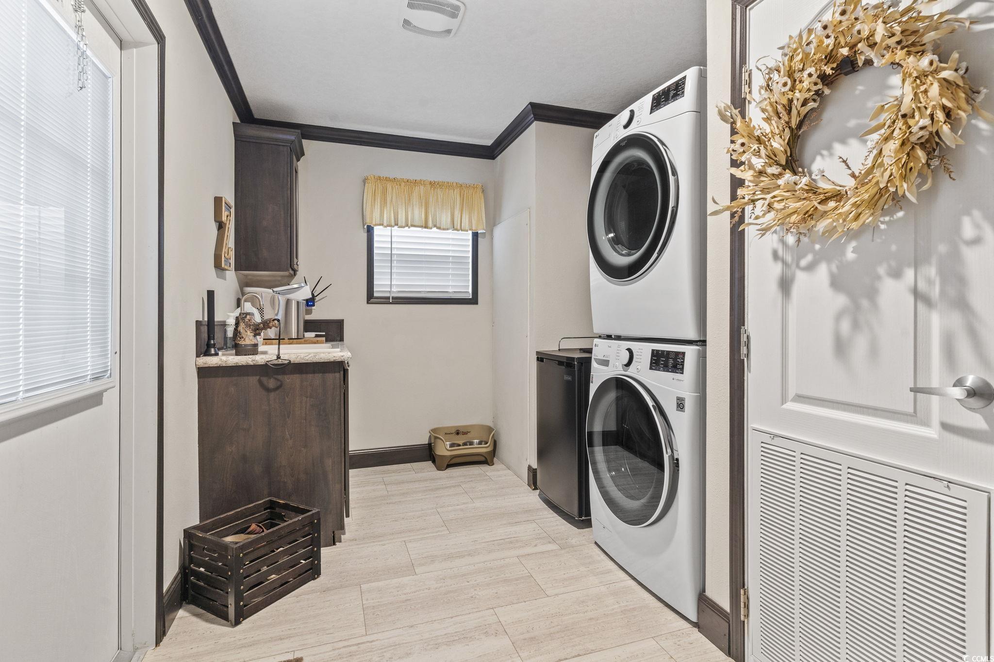 3085 Canady Lane Loris, SC 29569 - Photo 23 of 37 Laundry area featuring estacked washer and dryer and crown molding
