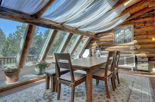 a view of a patio with couches and table and chairs with wooden floor