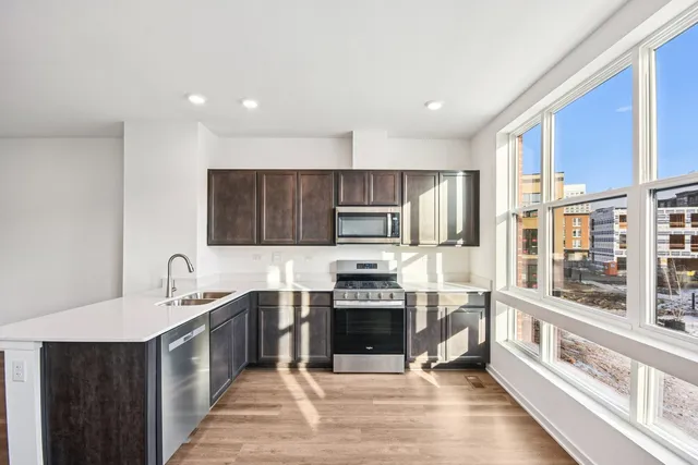 a large white kitchen with a sink and dish washer