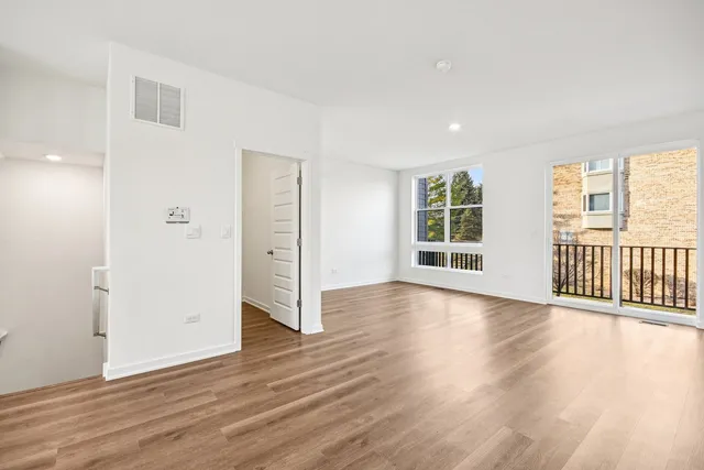 a view of a room with wooden floor and windows