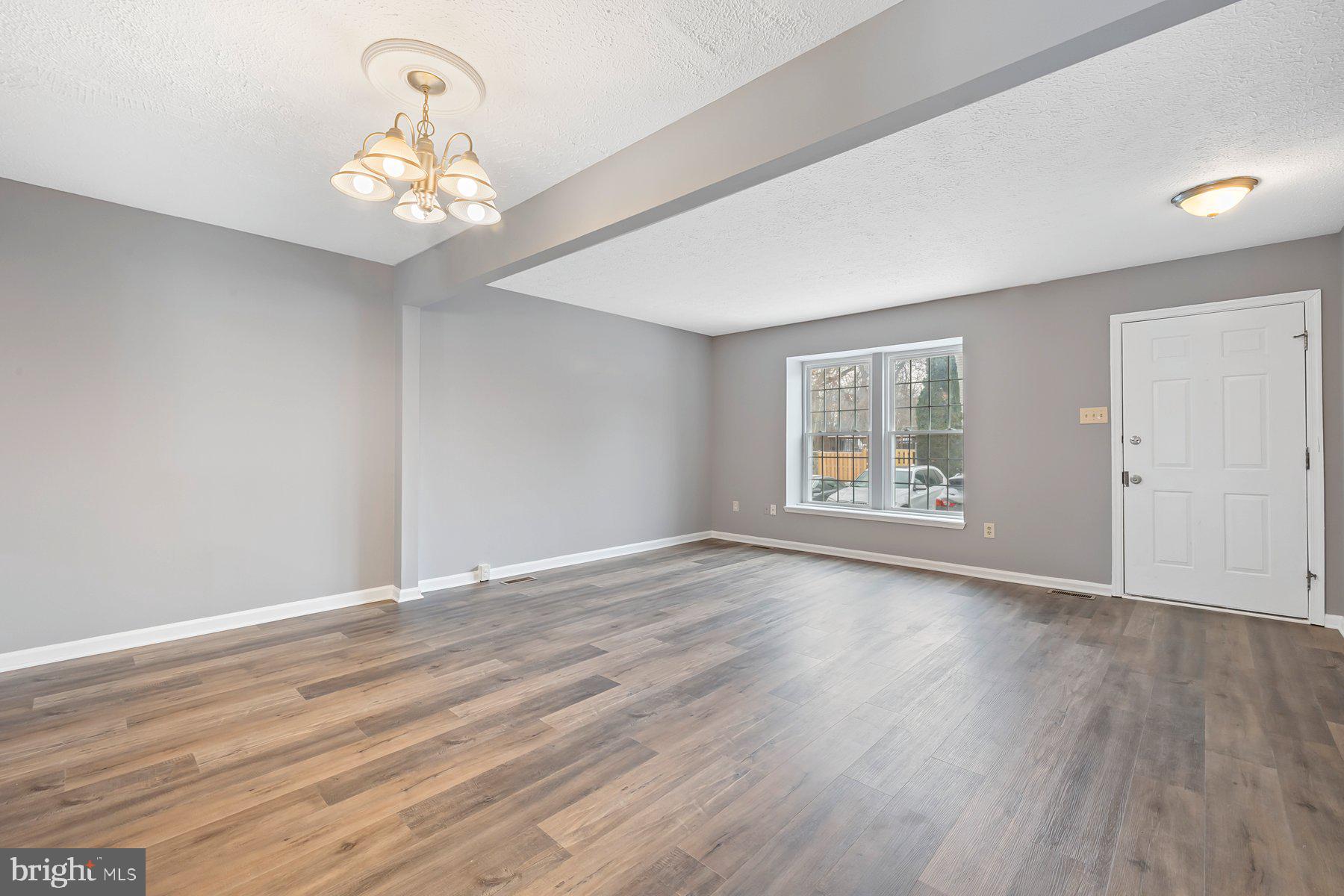 6795 Snow Goose Court Frederick, MD 21703 - Photo 4 of 36 a view of an empty room with wooden floor and a window