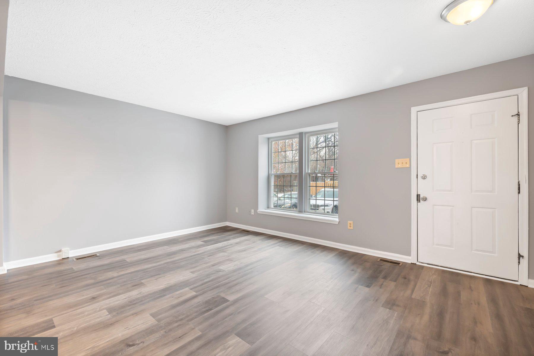 6795 Snow Goose Court Frederick, MD 21703 - Photo 7 of 36 an empty room with wooden floor and windows