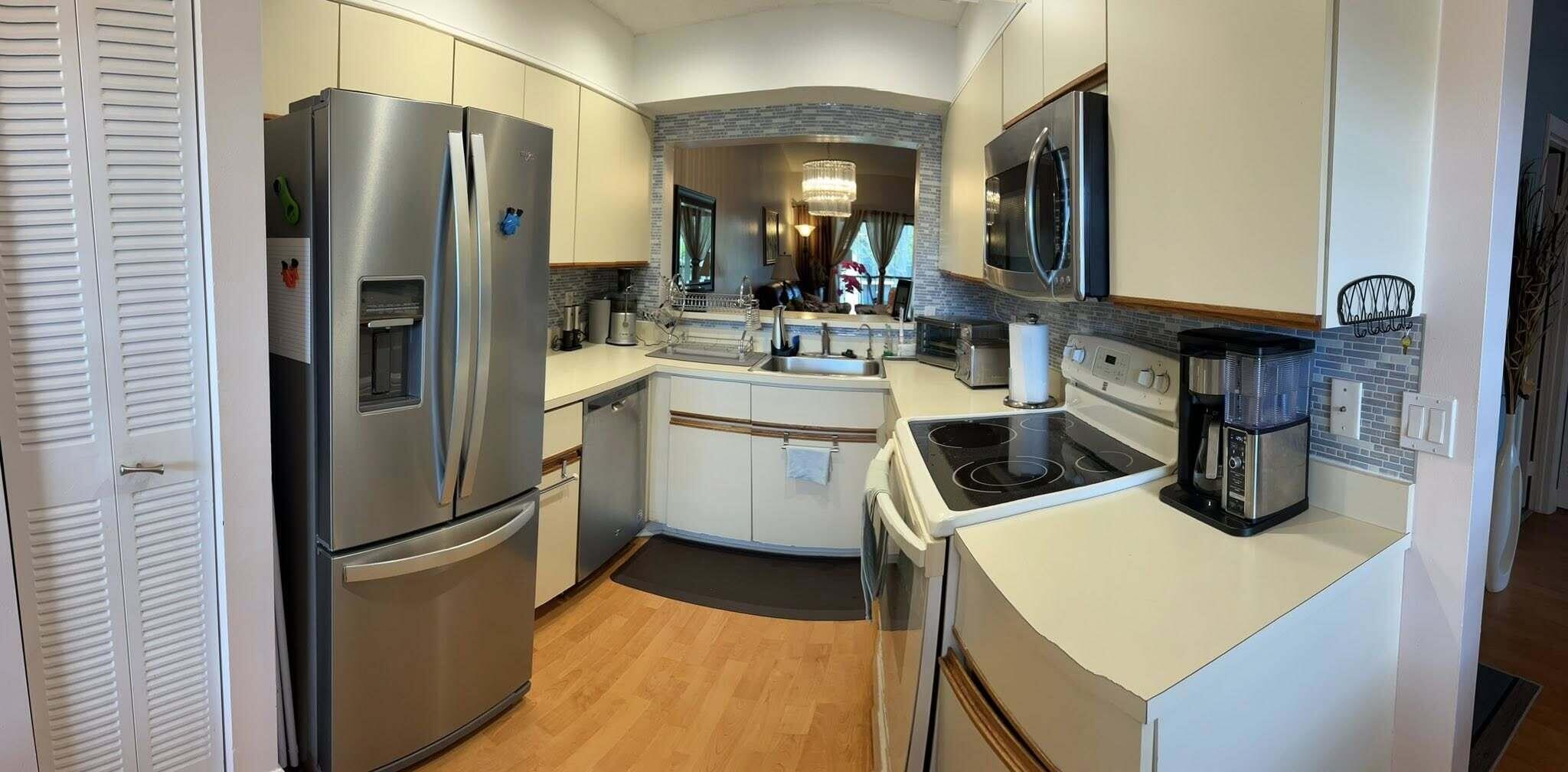 7855 Willow Spring Drive, Unit 726 Lake Worth, FL 33467 - Photo 4 of 16 a kitchen with a sink a refrigerator and cabinets