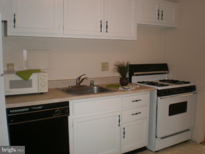 1836 Metzerott Road, Unit 1711 Hyattsville, MD 20783 - Photo 6 of 16 a kitchen with white cabinets and appliances