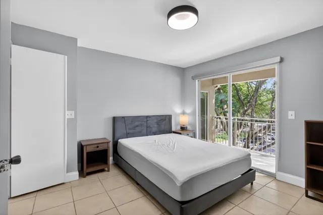 a large bedroom with a bed and glass door