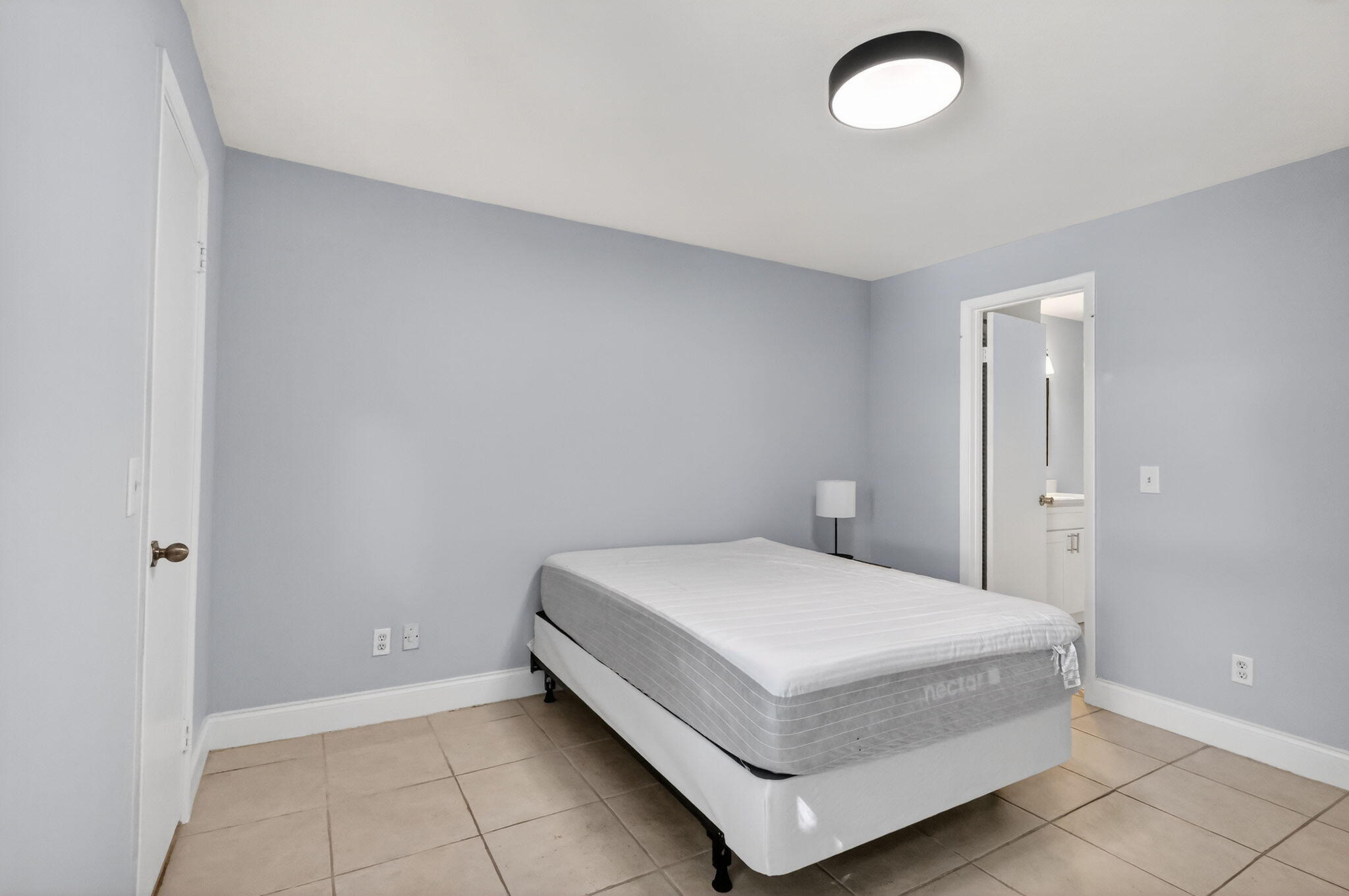 1740 Palm Cove Boulevard, Unit 4307 Delray Beach, FL 33445 - Photo 19 of 31 a room with a bed and a lamp