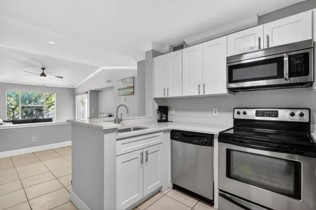 a kitchen with stainless steel appliances white cabinets and a stove top oven