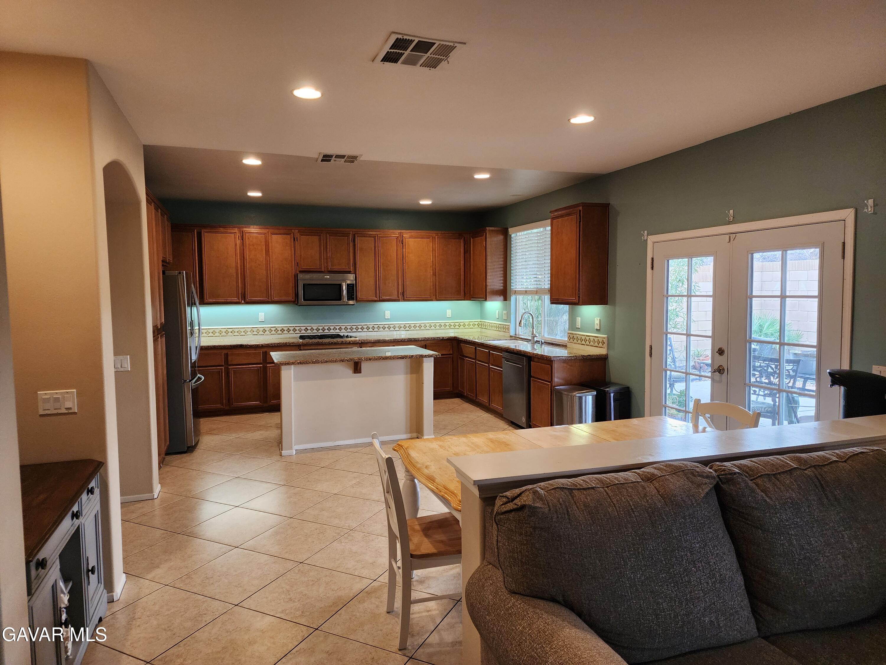 44741 Ruthron Avenue Lancaster, CA 93536 - Photo 4 of 13 a kitchen with stainless steel appliances granite countertop a refrigerator sink and cabinets
